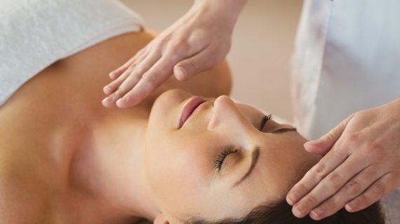 Young woman having a reiki treatment in therapy room